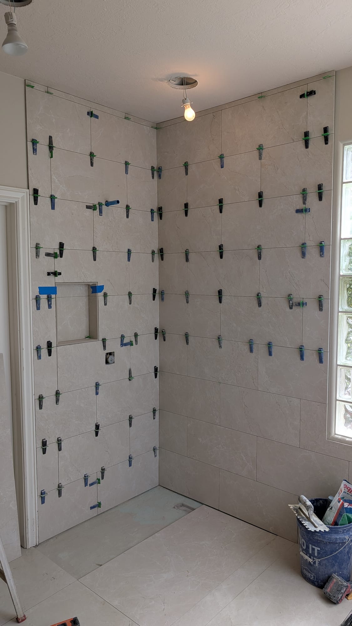 Large-format marble-look shower tile being installed by Haggerty Construction