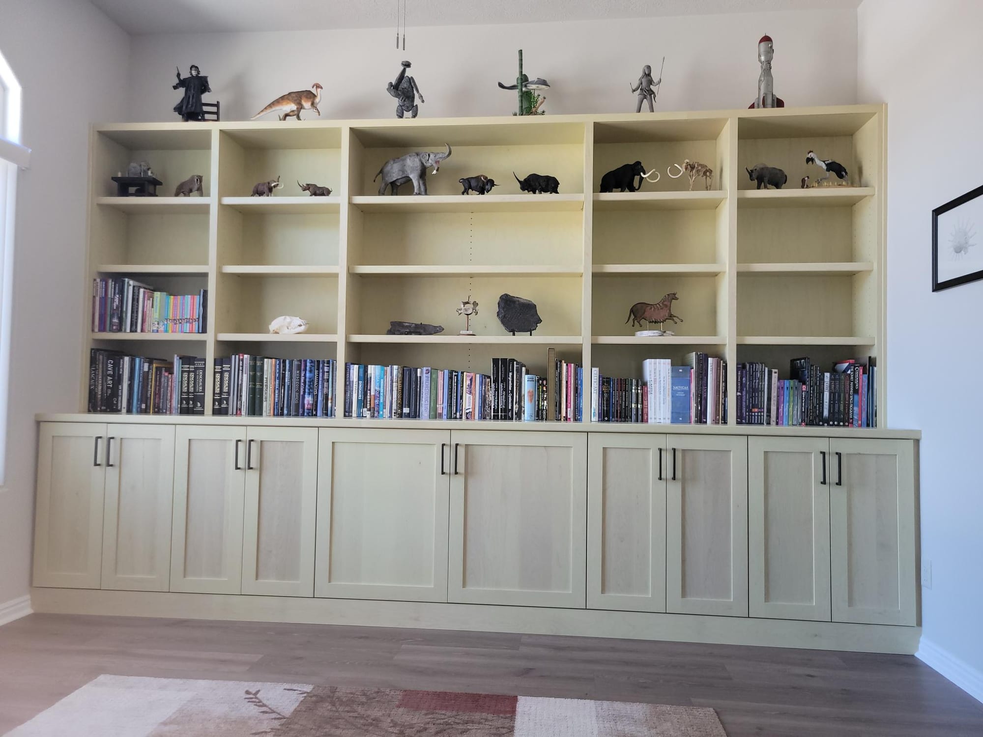 Finished full-wall custom built-in bookcase and cabinetry by Haggerty Construction