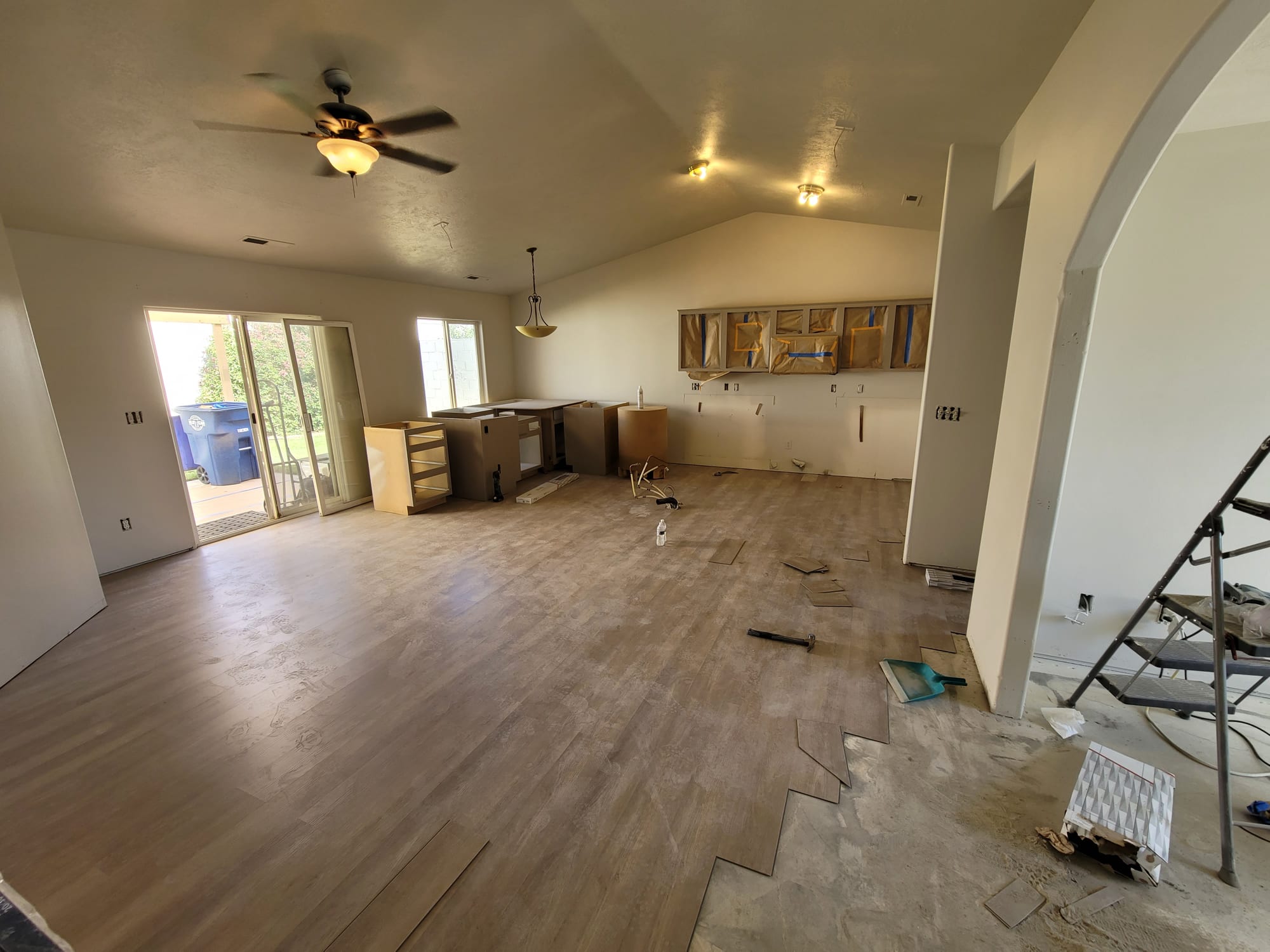 Open-concept great room mid-remodel with new flooring and cabinetry