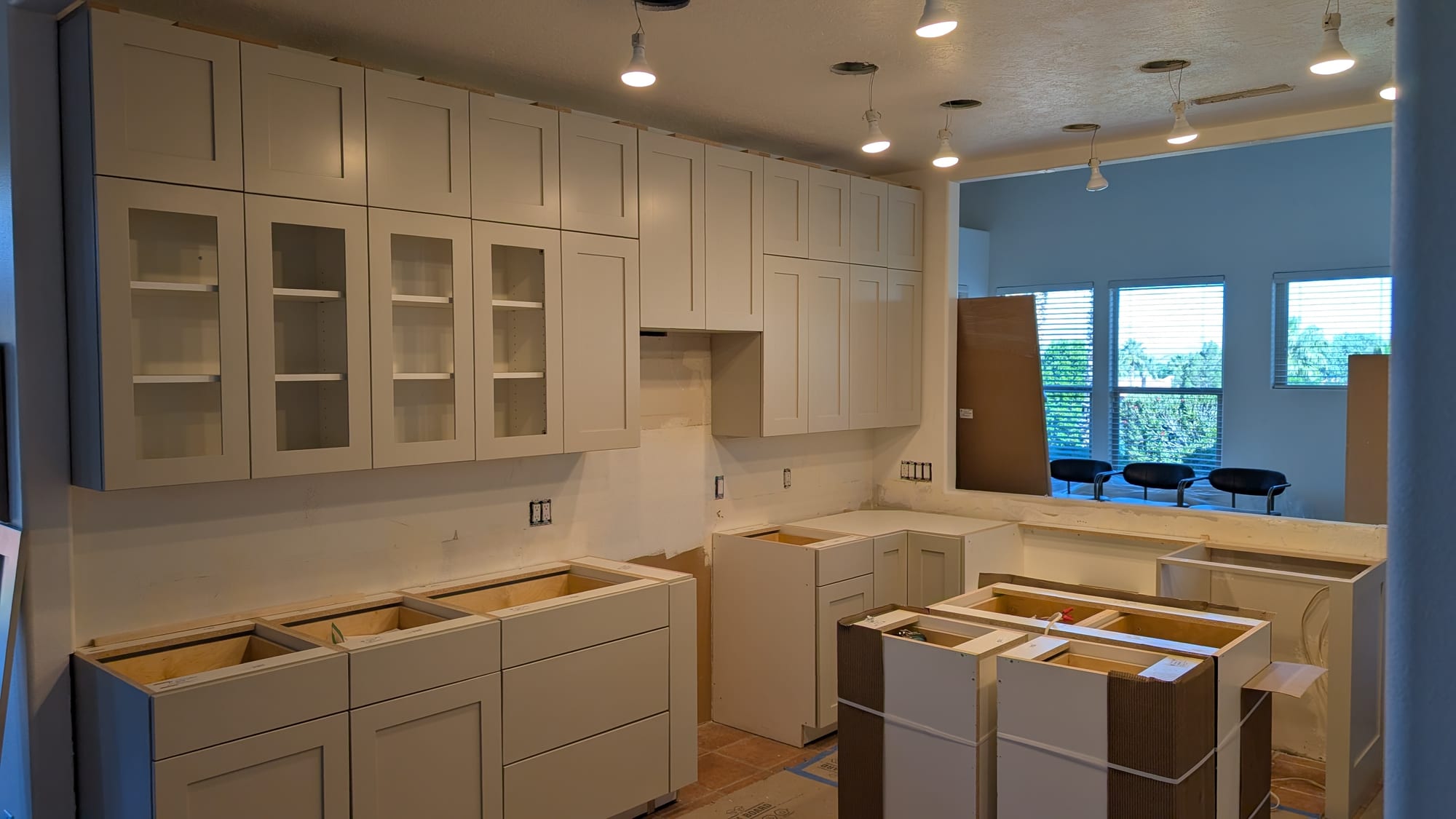 New white shaker cabinets being installed during a kitchen remodel