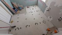 Bathroom floor tile being set with leveling clips by Haggerty Construction
