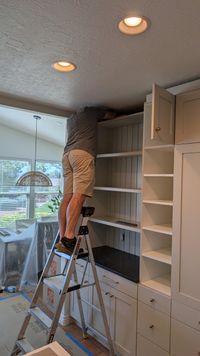 Installing tall cabinets beside a beadboard coffee bar during a kitchen remodel