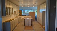 Kitchen flooring installation with new cabinets visible