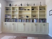 Custom light wood built-in bookcase with shaker cabinet storage