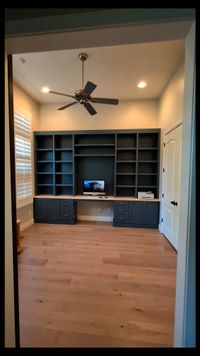 Custom dark blue office built-in with desk, shelving, and cabinet storage