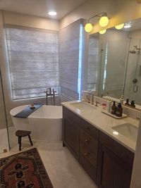 The primary bathroom with a freestanding tub, double vanity and frameless glass shower